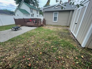 A backyard with a wooden deck, a patio table, and a shed. - Beautiful Bungalow nestled in Nelsonville near Hocking Hills (Nelsonville)