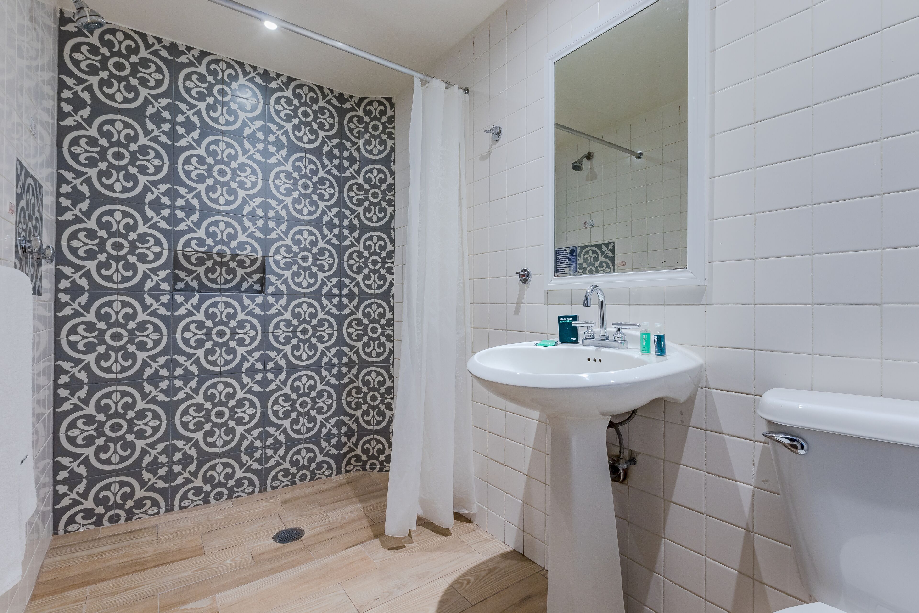 A bathroom with a shower, a sink, and a toilet.