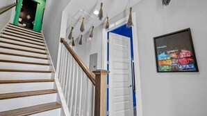 Eine Treppe mit hölzernen Stufen und einer grünen Tür am oberen Ende.