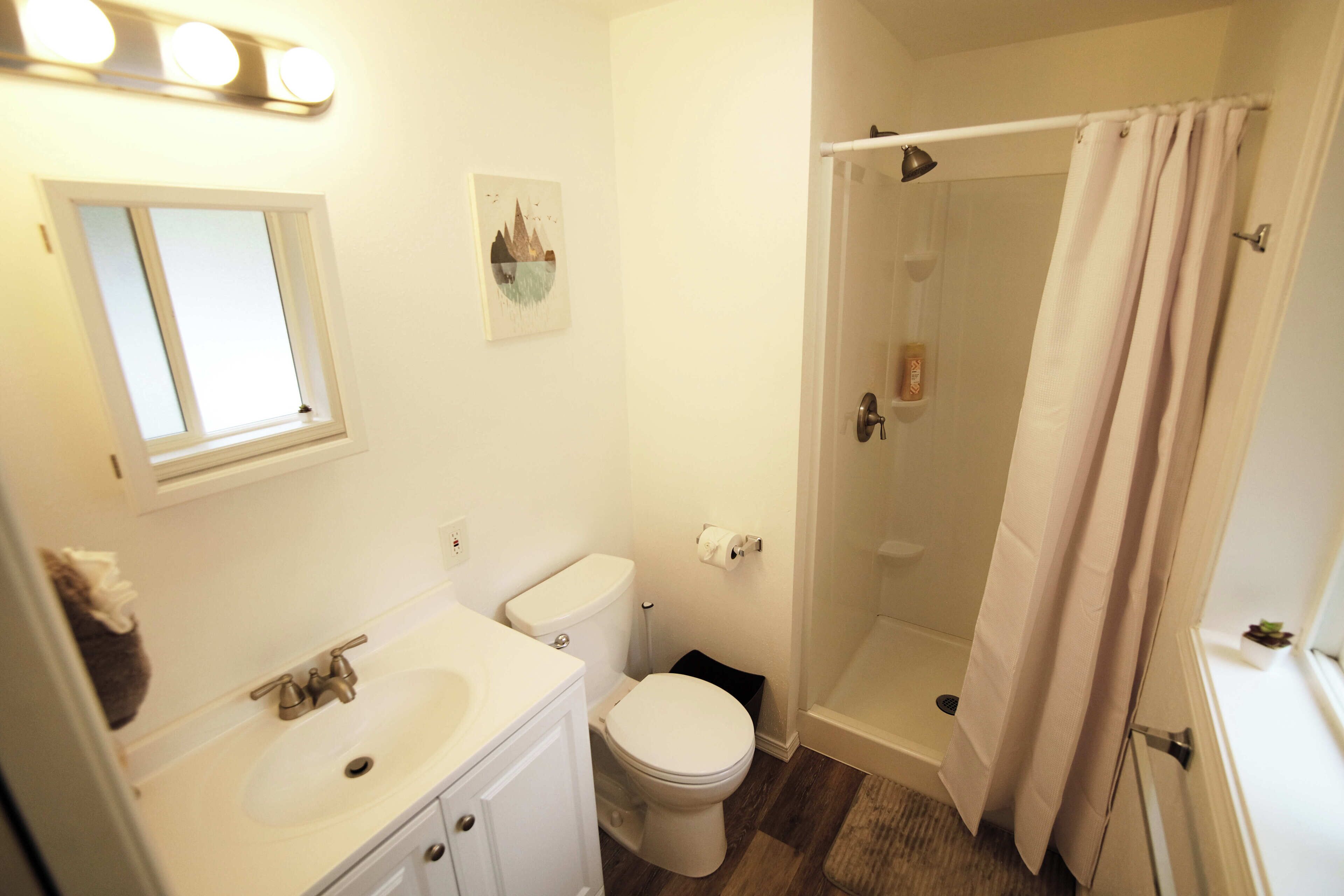 Un bagno con lavandino, WC e doccia.