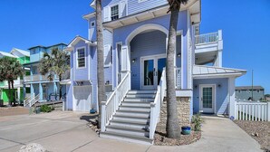 A two-story house with a front porch, a staircase, and a small front yard. - Sea the View Casita-ADA access + heated community pool.hot tub,beach boardwalk (Port Aransas)