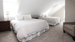 A bedroom with two beds, a nightstand, a chair, and a lamp. - Beautiful Lake Winnipesaukee Getaway in Wolfeboro (Wolfeboro)
