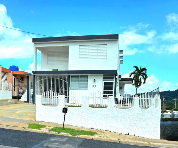 A modern two-story house with a white exterior, a gated front yard, and a mailbox. - Lomita Linda just minutes from San Juan and Central to all Puerto Rico  (Caguas)