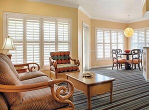 Relax in this inviting space, featuring a comfortable sofa, armchair, and dining table for four.