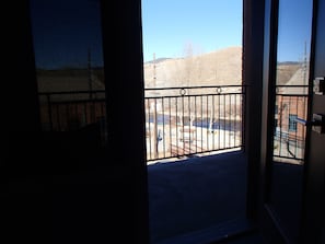 Enjoy the view from this balcony overlooking the parking area and surrounding buildings.