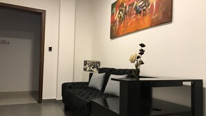 Un saló modern amb un sofà, una taula de centre i un quadre a la paret.