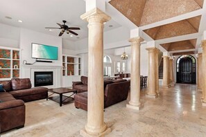 A spacious living area with a fireplace, leather sofas, and a television.