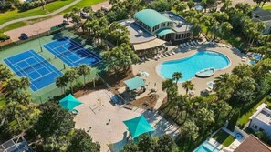 An aerial view of a resort with multiple tennis courts, a swimming pool, and a clubhouse.
