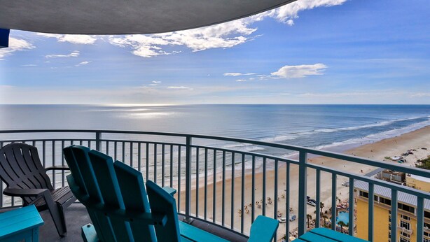 Un balcon avec des chaises donnant sur une plage.