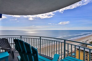 Varanda com cadeiras voltada para uma praia.
