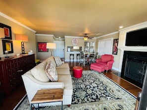 Cozy living space with a fireplace, comfortable seating, and elegant artwork.