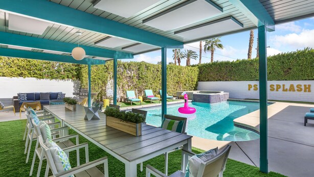Un espace extérieur abrité avec une piscine, des sièges et un panneau indiquant « PS SPLASH ».