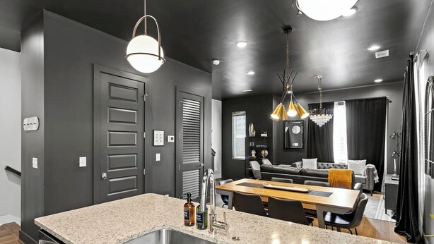 A modern kitchen with granite countertops, stainless steel appliances, and pendant lighting. - Night Lounge | Luxe Rooftop Retreat + City Views (Nashville)