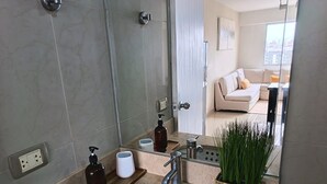 A modern bathroom with a sink, mirror, and toiletries.