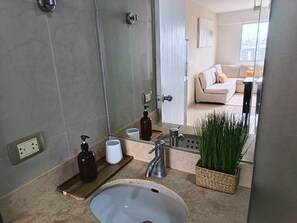 Une salle de bain moderne avec un lavabo, un miroir et des articles de toilette.