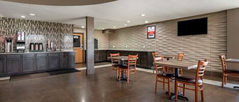 A modern restaurant with a curved ceiling, a bar area, and a dining section with wooden tables and chairs.