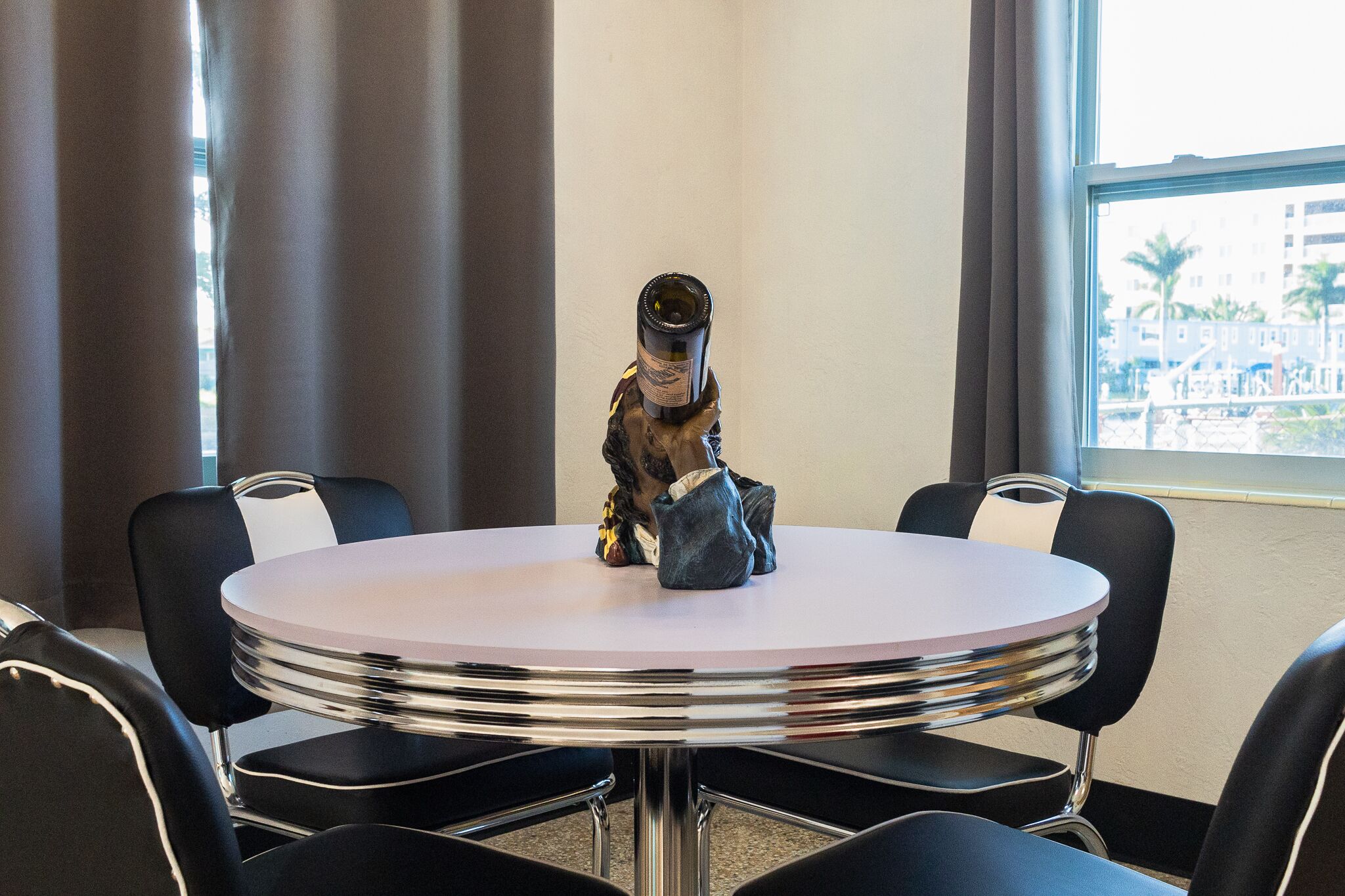 A conference room with a round table, black chairs, and a statue of a person.