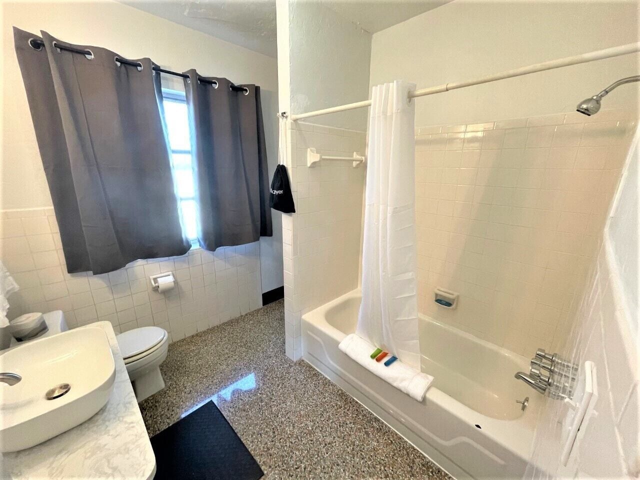 A bathroom with a toilet, sink, bathtub, and shower.
