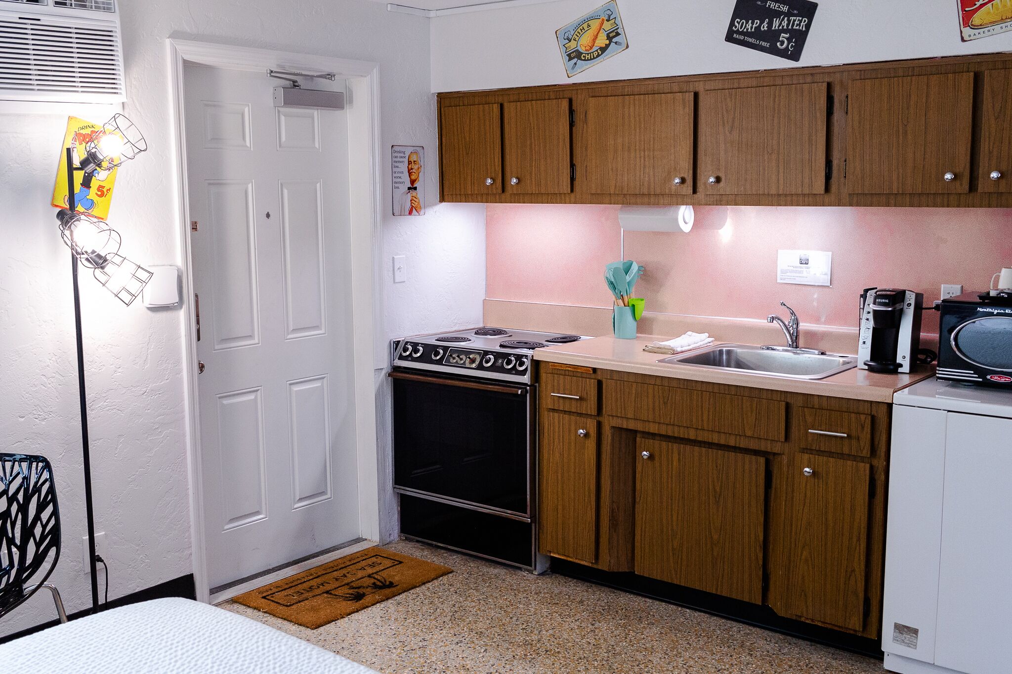 A compact kitchen with wooden cabinets, a stove, and a sink.
