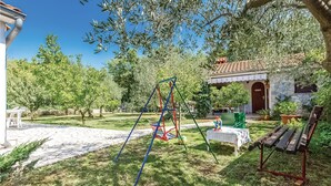 Un jardín con un columpio, una banca y una mesa.