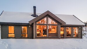Suuri, moderni talo, jossa on useita suuria ikkunoita ja huomiota herättävä savupiippu.