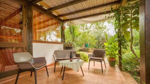 A covered patio with four chairs, a small table, and a bottle of wine. - Lovely home in Menfi with WiFi (Menfi)