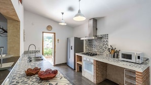 Een moderne keuken met een centraal eiland, een ingebouwde oven en een magnetron.