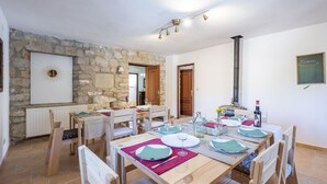 Un espace repas avec un mur en pierre, des meubles en bois et un menu affiché au mur.