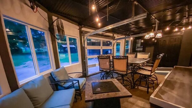 An indoor dining area with a sofa, dining table, chairs, and large windows. - Right in Nashville, One of the last standing farms (Nashville)