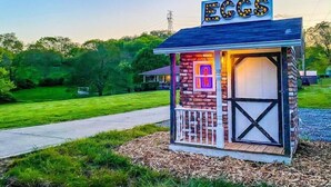 A small brick structure with a sign reading "EGGS" and a window with illuminated numbers. - Right in Nashville, One of the last standing farms (Nashville)