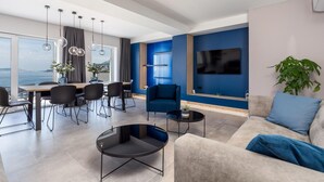 A modern living room with a dining area, a large TV, and a view of the sea. - Stunning home in Prizna (Prizna)