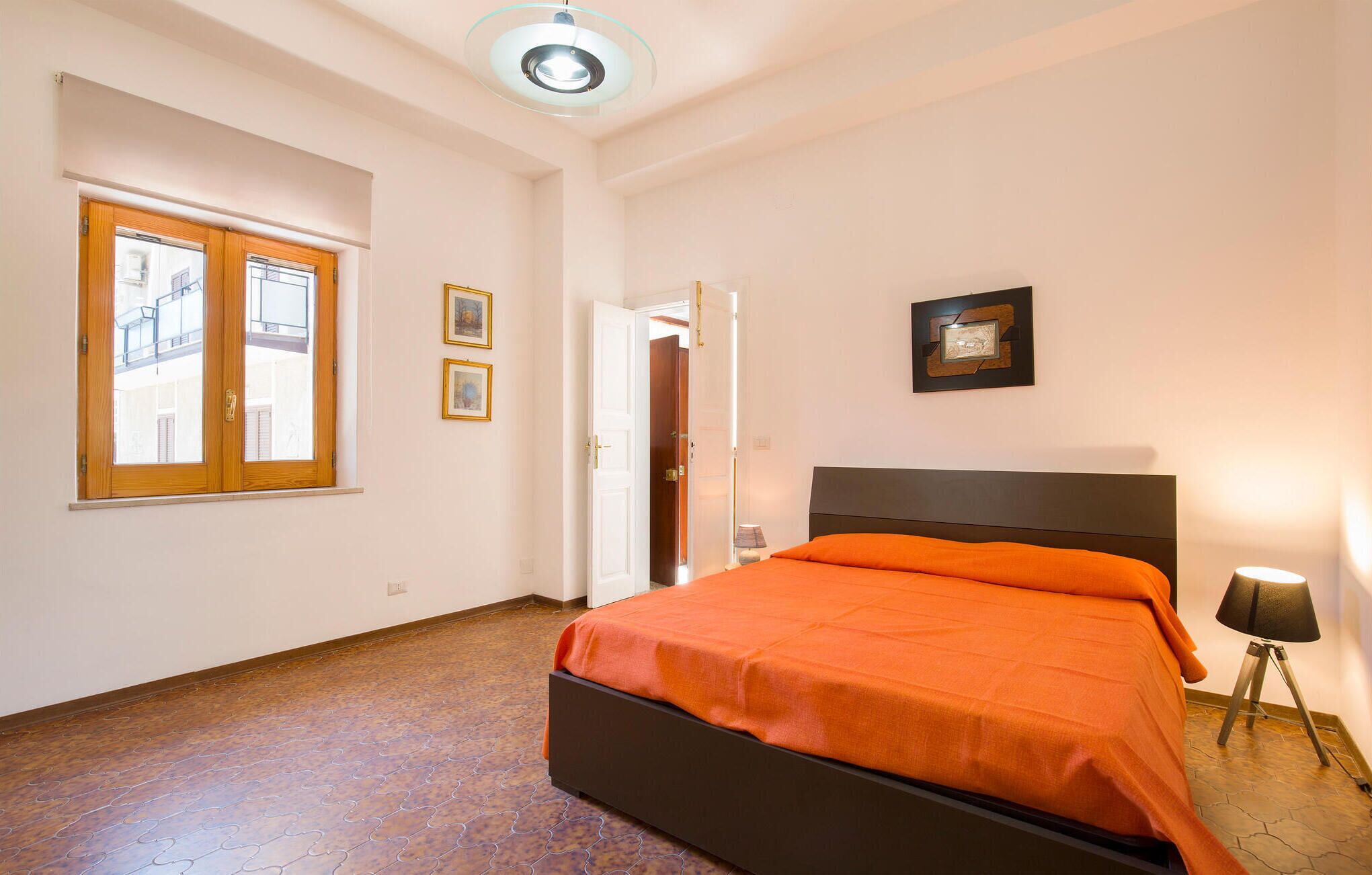 Une chambre à coucher avec un lit, une fenêtre et une porte.