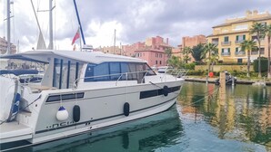 A white yacht docked at a marina with a cityscape in the background. - Nice home in Algatocin (Algatocin)