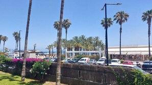 A parking area with palm trees and a building in the background. - Nice apartment in Torremolinos with swimming pool (Torremolinos)