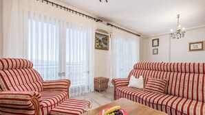 A living room with striped sofas, a wooden coffee table, and a fruit bowl. - Stunning apartment in Opatija with WiFi (Opatija)