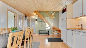 Eine moderne Küche mit Holzausstattung, einem eingebauten Ofen und einer Spüle aus Edelstahl.
