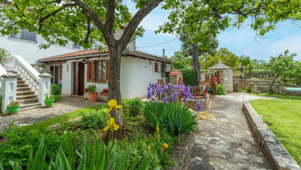 A house with a stone pathway, a small garden with flowers, and a white building with a red roof. - Awesome home in Kanfanar with WiFi (Kanfanar)