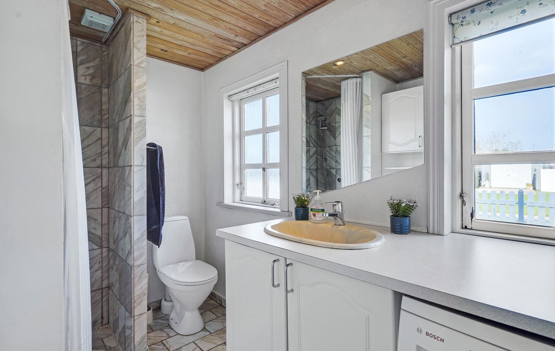 A bathroom with a toilet, sink, and shower.