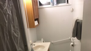 Ein kleines Badezimmer mit Dusche, Toilette und Waschbecken.