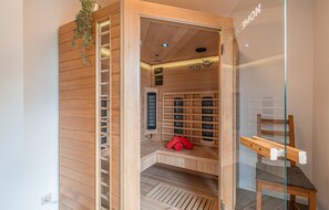 A sauna room with wooden walls, a bench, and a towel rack.