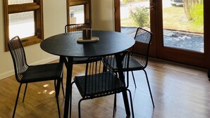 A dining area with a round table, four chairs, and a hanging light fixture. - 5-Star Lux Modern Cabin in DT Fruita ❊ Dog Friendly❊ (Fruita)