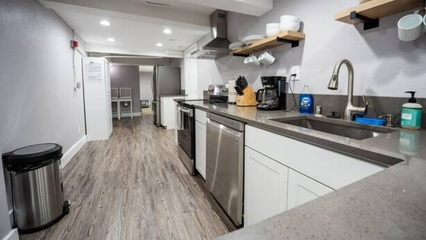 A modern kitchen with a central island, stainless steel appliances, and wooden flooring. - Beautiful Downtown Tacoma Home Unit 2 (Tacoma)