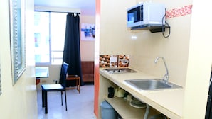 A compact kitchen with a sink, microwave, and tiled backsplash. - 1C19 Apartamento Cartagena frente al mar (Cartagena)