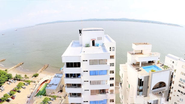 A high-rise hotel with multiple balconies overlooking a beach and the sea. - 1C19 Apartamento Cartagena frente al mar (Cartagena)