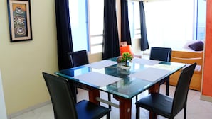 A dining area with a glass table, black chairs, and a small plant centerpiece. - 1C19 Apartamento Cartagena frente al mar (Cartagena)