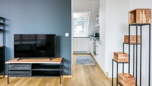 Un salon moderne doté d’un téléviseur à écran plat, d’une table basse en bois et d’un meuble TV avec des tiroirs.