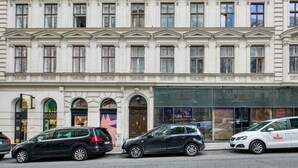 Un bâtiment à la façade classique, doté de nombreuses fenêtres et d’une devanture avec de grandes vitrines.