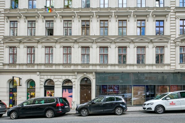 A building with a classical facade, multiple windows, and a storefront with large glass windows.