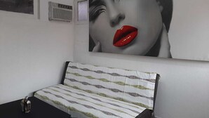 A room with a striped headboard, a small table, and a wall-mounted air conditioning unit. - 1G3-2 Apartamento en la Ciudad Antigua (Cartagena)