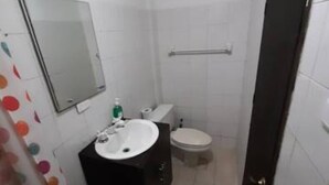 A small, compact bathroom with a white sink, a toilet, and a mirror on the wall. - 1G2-3 Apartamento en la ciudad Antigua (Cartagena)